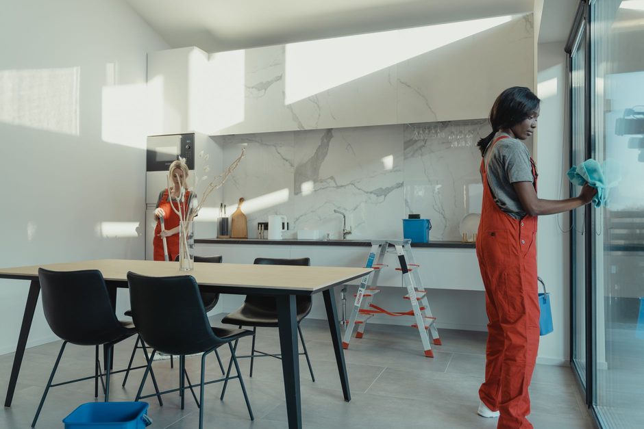 Two cleaners at work in a bright modern kitchen