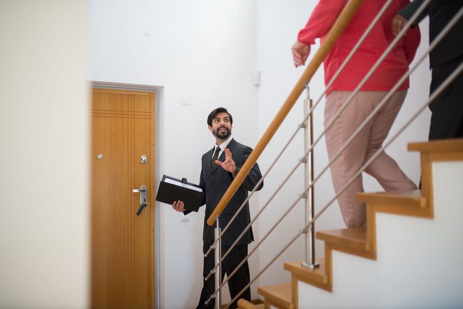 Estate agent showing a couple around a home