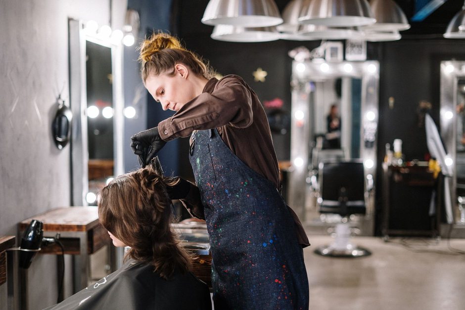 Hairdresser colouring a client’s hair in a salon